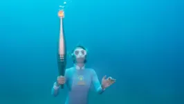 Mergulhadora conduz tocha olímpica durante trecho do revezamento pelo Mar Mediterrâneo.