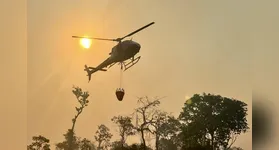 Helicóptero lança água em cima dos focos de incêndios