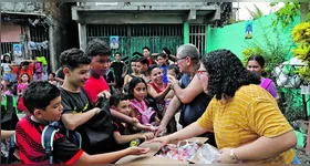 O devoto Carlos Santos mantêm a tradição de distribuir bombons no dia dos santos gêmeos