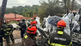 Agente da Polícia Federal e equipes do Corpo de Bombeiros trabalham na retirada dos corpos das 62 vítimas do acidente aéreo em Vinhedo (SP).