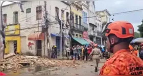 O desabamento atingiu três carros e uma motocicleta, além de derrubar um poste, espalhando destroços pela via.