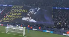 Torcida do City exibe faixa com imagem de Rodri beijando a Bola de Ouro antes da partida contra o Real Madrid na Champions League.