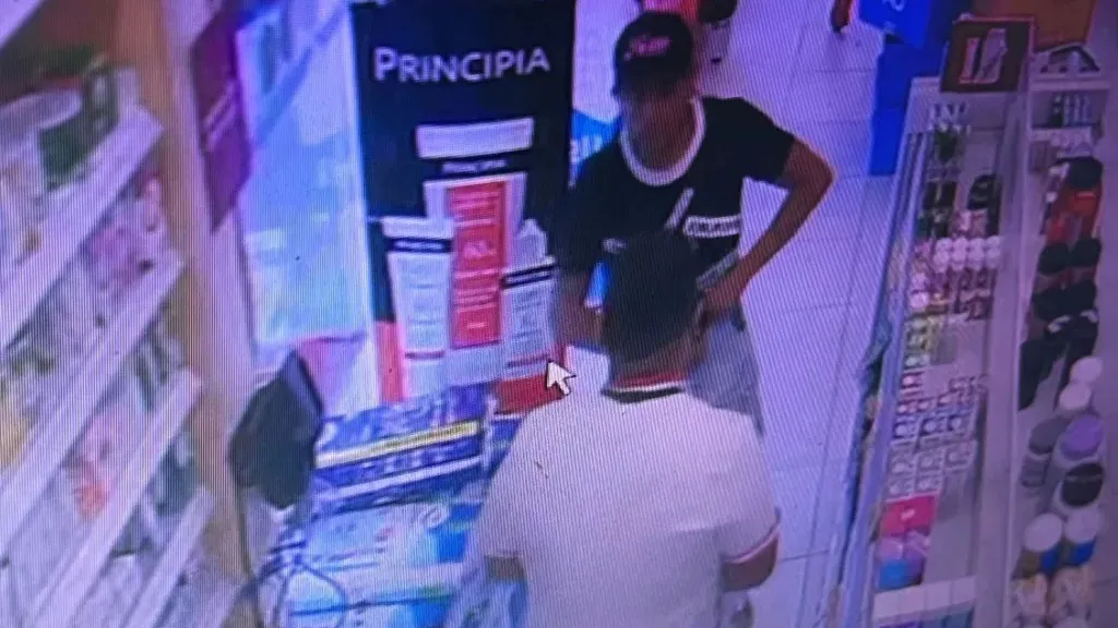 Um dos suspeitos anuncia o assalto na farmácia