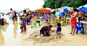 Nem a chuva afastou os banhistas de Outeiro, como Heraldo Pinheiro (abaixo), que levou a família para curtir a praia