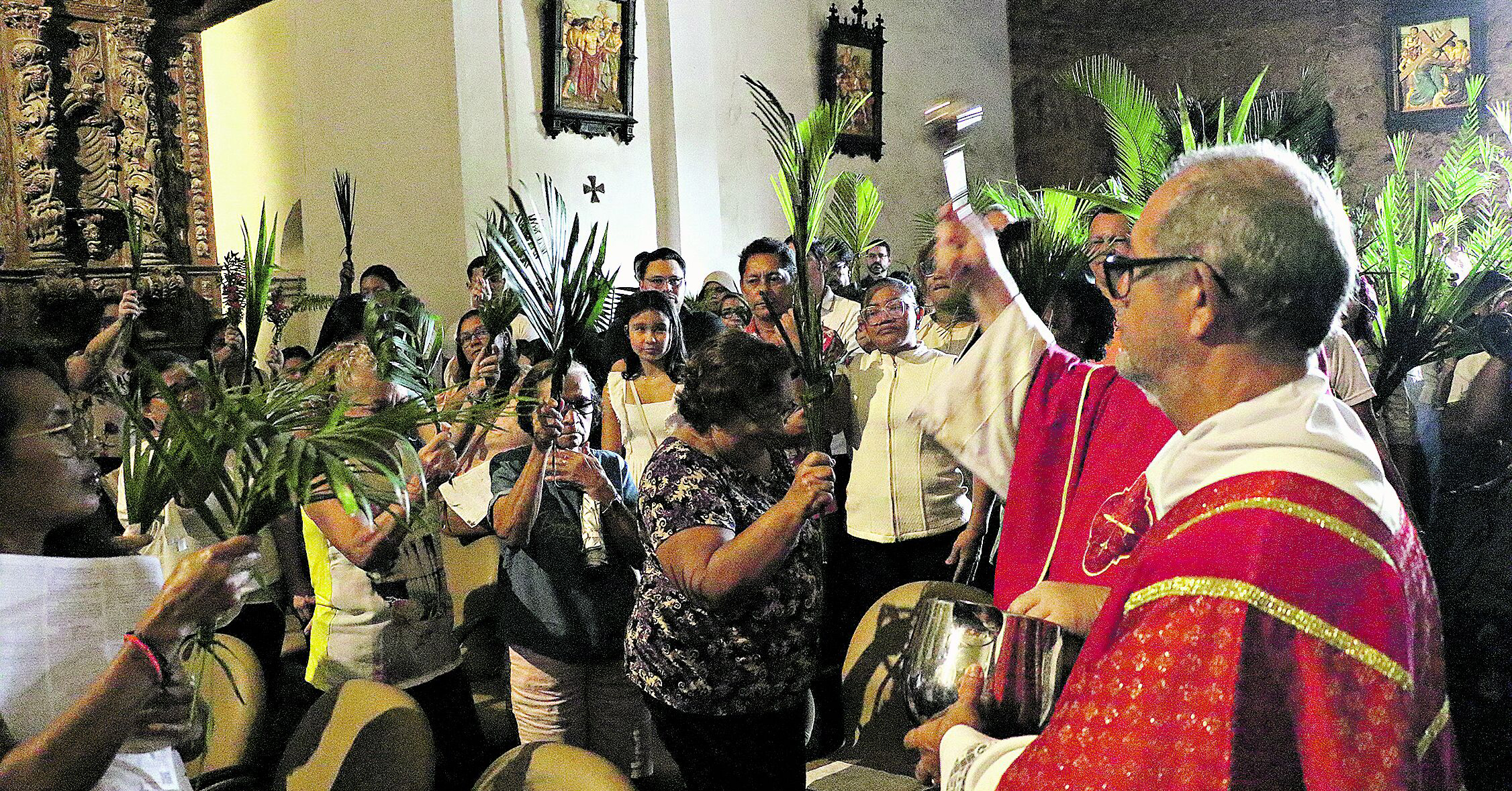 Fiéis seguram ramos na data que inicia a Semana Santa para relembrar a entrada de Jesus Cristo em Jerusalém