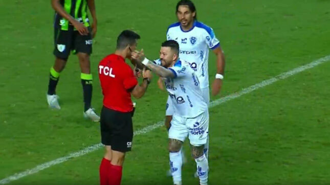 O atacante encosta as mãos na bochecha do árbitro, diz “obrigado” ao árbitro e, na sequência, volta a correr para celebrar o lance.