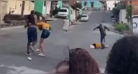 O homem agride a vítima covardemente em meio a várias pessoas que assistem e não fazem nada.