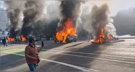 Viaturas da polícia forsm incendiadas durante protestos em Los Angeles.