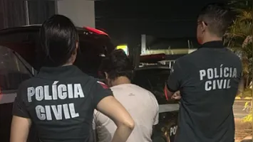 Uma das suspeitas sendo detida pelos policiais