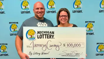 Tammy Carvey e seu marido, David, segurando o 'cheque' de US$ 100.000