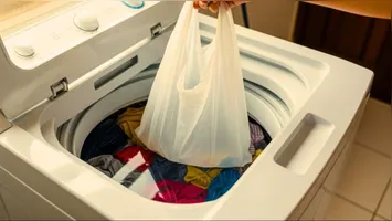 Saco plástico cria barreira protetora entre a peça e o restante das roupas na máquina de lavar.