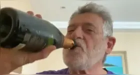 Ator aparece abrindo uma garrafa de champanhe ao som do hino nacional