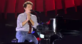 Sentado em sua cadeira, o cantor emocionou os fãs