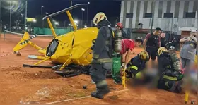 Equipes de emergência trabalharam ao redor do helicóptero destruído após pouso forçado em quadra de tênis no Parque Manuel Belgrano, em Buenos Aires.