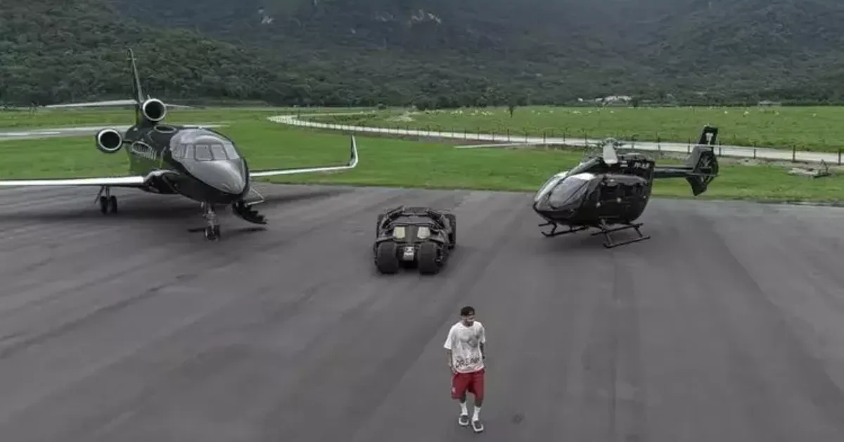 Neymar posa ao lado da réplica do Batmóvel em sua mansão em Mangaratiba; veículo faz parte de uma coleção avaliada em centenas de milhões de reais.