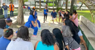 Acompanhantes participam de exercícios de alongamento conduzidos pela equipe de reabilitação no Hospital Metropolitano de Urgência e Emergência, em Ananindeua, durante ação inspirada no Carnaval.
