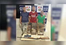 Material apreendido pela Polícia Militar inclui porções de cocaína, arma de fogo e aves silvestres resgatadas durante a ação.
