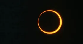 Os raios passam pelas bordas do planeta e chegam até a Lua com predominância de tons vermelhos e alaranjados.