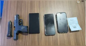 Arma de fogo de uso restrito e celulares apreendidos durante a ação policial que resultou na prisão dos suspeitos.