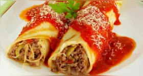 Panquecas brasileiras clássicas ganham toque especial com recheio cremoso de carne, molho caseiro e queijo gratinado