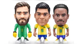 O goleiro Alisson, o volante Casemiro e o zagueiro Gabriel Magalhães. A mistura de jogadores atuais com o visual nostálgico das miniaturas cria um produto que atravessa gerações.