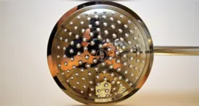 O acúmulo de minerais como cálcio e magnésio nos furinhos do chuveiro reduz a pressão da água, mas a limpeza periódica ajuda a desentupir o espalhador e recuperar o jato forte.