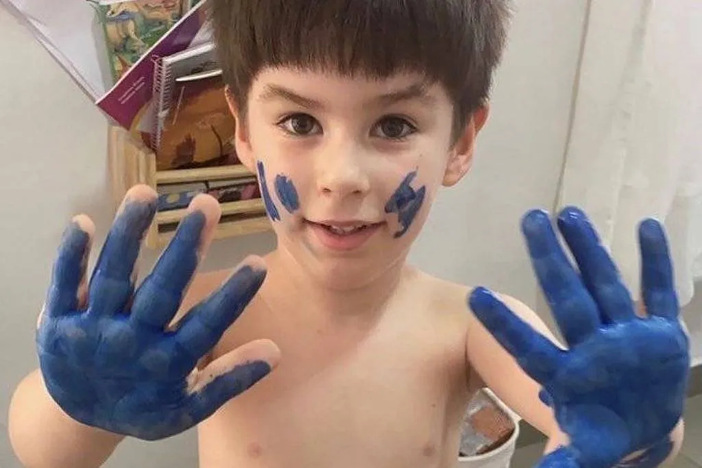 O menino Henry Borel, morto aos 4 anos, brincando com tintas