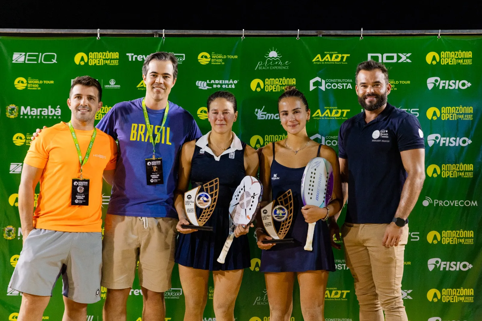 Cariani e Mola com o troféu no centro e vibrando e Chow/Marchezini ao centro na premiação e italianas com o troféu