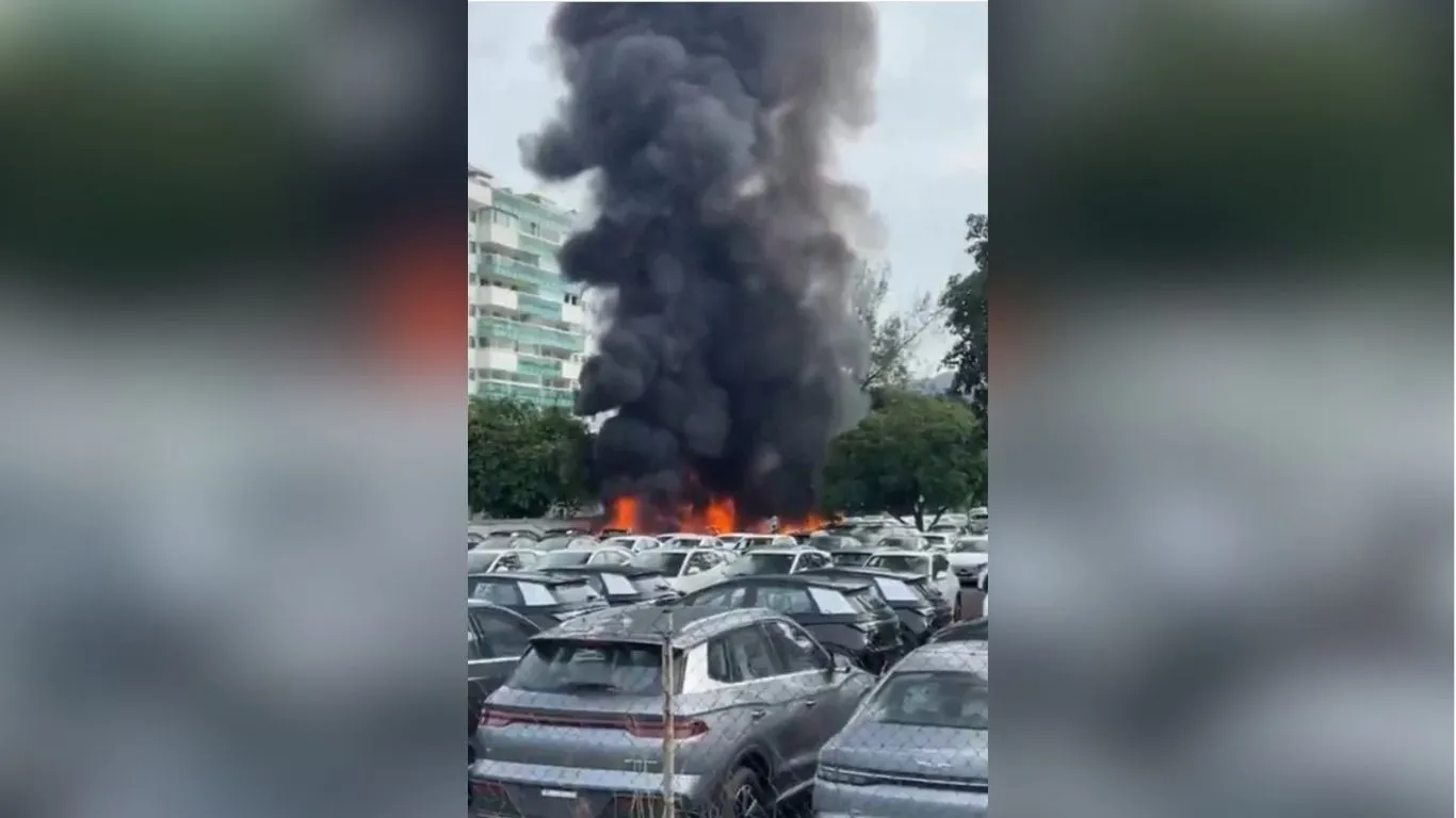 Equipes do Corpo de Bombeiros trabalham no pátio de estacionamento no Recreio dos Bandeirantes onde um dos helicópteros caiu e atingiu carros elétricos.