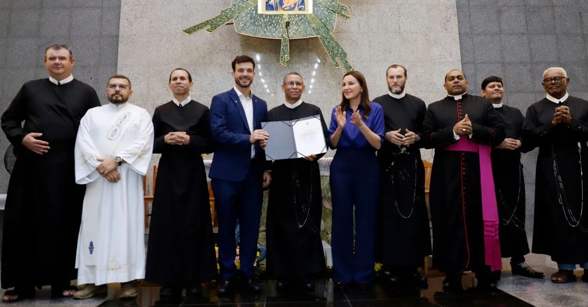A governadora Hana junto aos padres do Santuário exibe o documento que confirma as novenas Patrimônio
