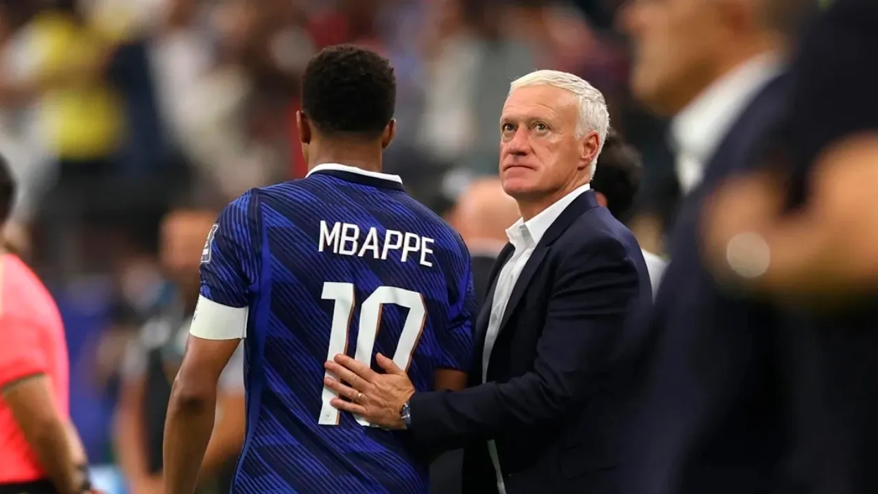 O técnico Didier Deschamps observa a partida com semblante sério à beira do gramado, lamentando o baixo rendimento da França e a eliminação na Copa do Mundo de 2026.