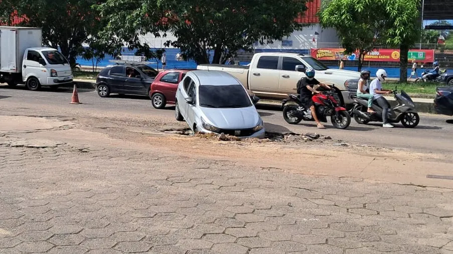 Motorista caiu no buraco ao tentar acessar um posto de combustível.