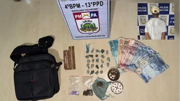 Porções de crack, maconha, comprimidos e dinheiro em espécie apreendidos na bolsa do suspeito durante a revista policial.