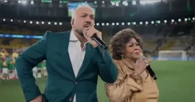 Belo e Alcione se atrapalham ao cantar o Hino Nacional no amistoso Brasil x Panamá