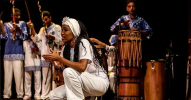Com duração de uma hora, a montagem leva ao palco uma experiência cênico-musical que percorre a história da resistência do povo negro por meio da Capoeira Angola e de manifestações tradicionais como o Tambor de Crioula, o Bumba Meu Boi, o Samba e as tradições de matriz africana.