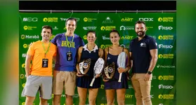 Cariani e Mola com o troféu no centro e vibrando e Chow/Marchezini ao centro na premiação e italianas com o troféu
