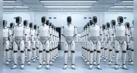 Robô humanoide realiza testes de manipulação de peças em linha de montagem ao lado de operários.