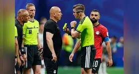 À beira do gramado, o técnico Hossam Hassan gesticula e reclama com a arbitragem francesa antes de ser advertido com o cartão amarelo.