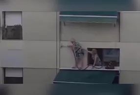A gravação mostra uma das mulheres posicionada na janela