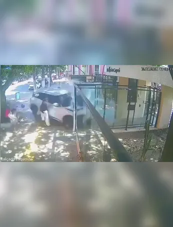 Nos registros, uma mulher de blusa preta e calça branca por pouco não é atingida pelo veículo, que passa de raspão, atinge a vidraça de um edifício e para em frente ao prédio.
