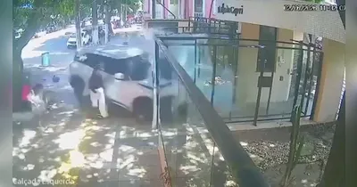 Nos registros, uma mulher de blusa preta e calça branca por pouco não é atingida pelo veículo, que passa de raspão, atinge a vidraça de um edifício e para em frente ao prédio.