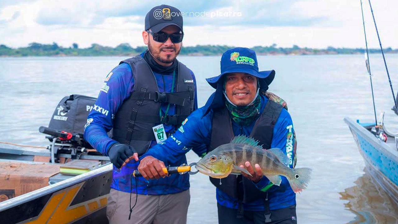 Pescador exibe exemplar de tucunaré antes de devolvê-lo ao Rio Araguaia; prática do "pesque e solte" garante a preservação das espécies e atrai turistas ao Pará.
