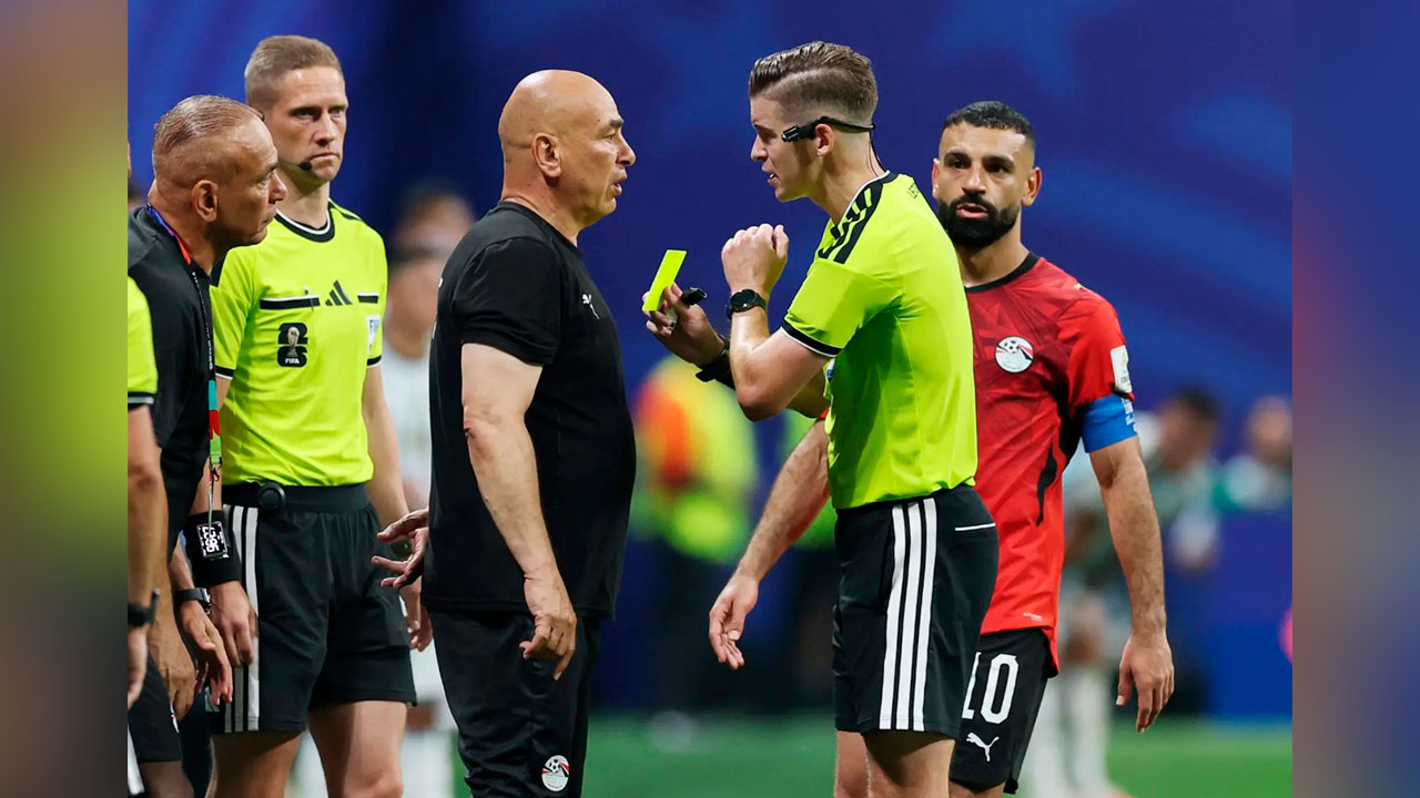 À beira do gramado, o técnico Hossam Hassan gesticula e reclama com a arbitragem francesa antes de ser advertido com o cartão amarelo.