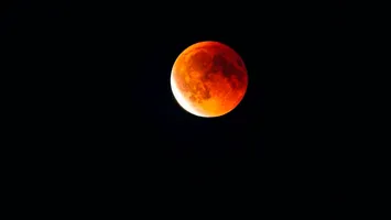 Aparência avermelhada da Lua durante eclipse parcial; brasileiros poderão observar até 95% do satélite coberto na madrugada de 27 para 28 de agosto.