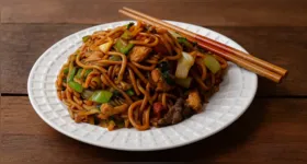 Yakissoba caseiro preparado com espaguete, carne, legumes e molho shoyu é uma opção prática para o almoço ou jantar.