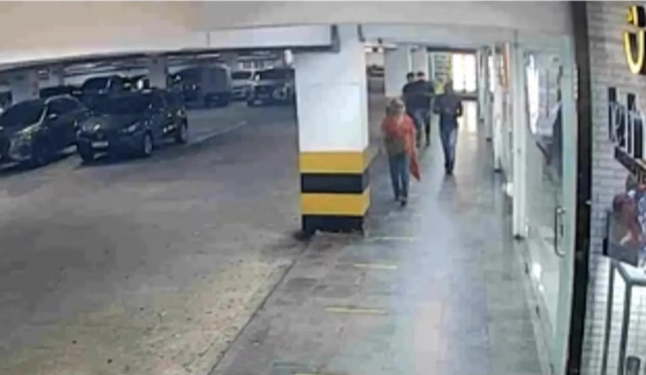Câmeras de monitoramento mostram os suspeitos perseguindo a vítima (camisa laranja) em estacionamento