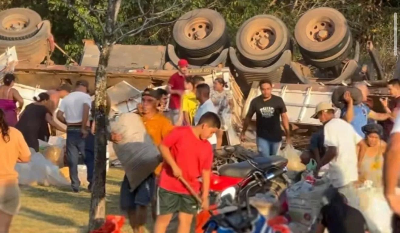 Caminhão tomba e carga que foi esparramada no chão é saqueada por populares