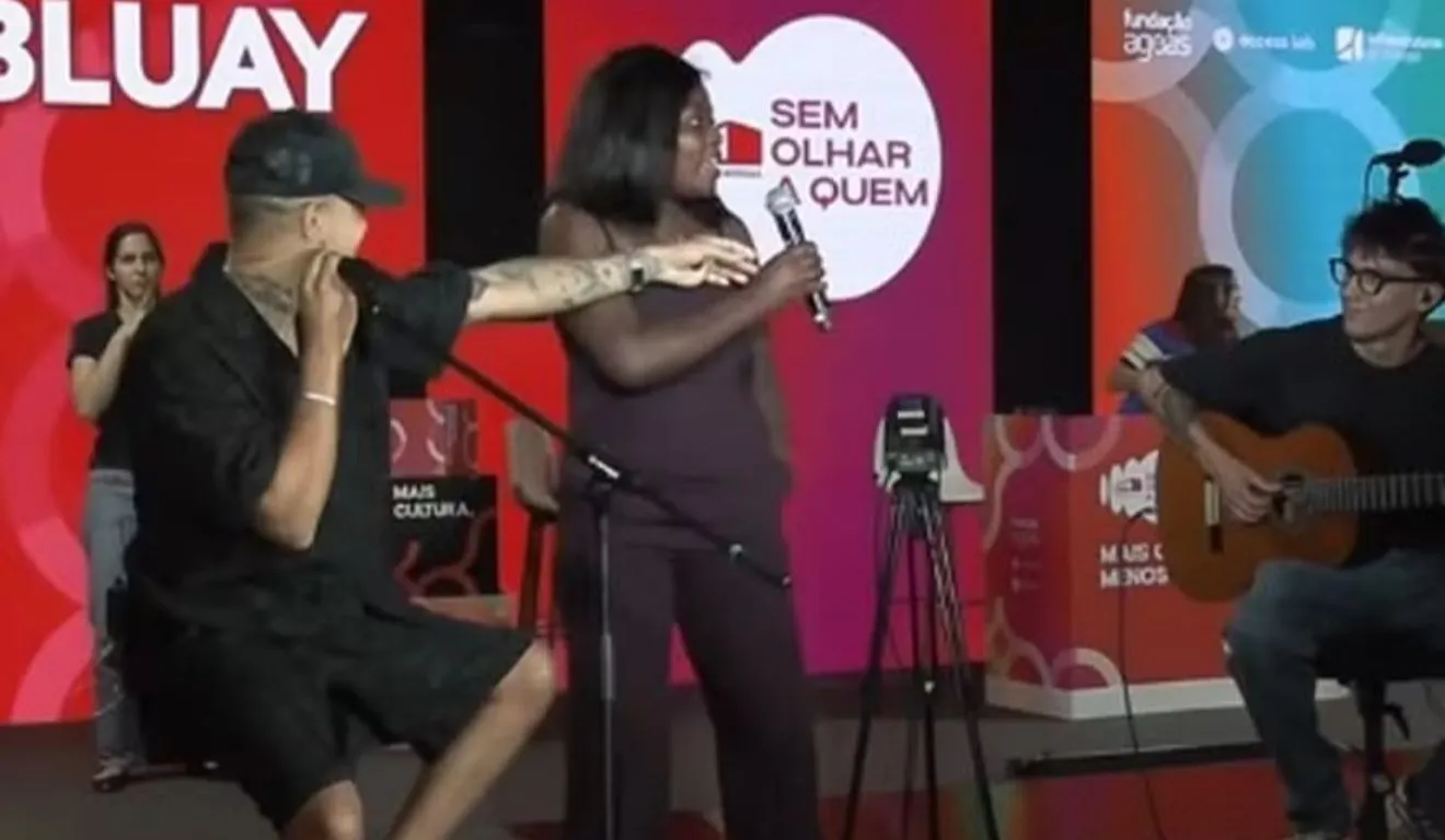 Nas imagens que circulam na internet, ela aparece ao lado do artista e começa a cantar uma frase que rapidamente virou meme: “O que tem no carro?”