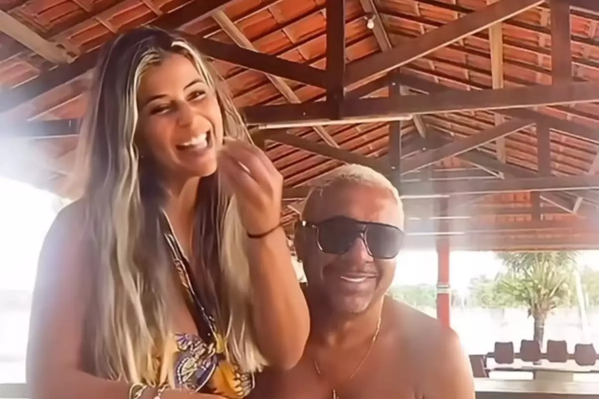 Na gravação, Nana aparece sentada no colo do marido, rindo e dando comida na boca dele.