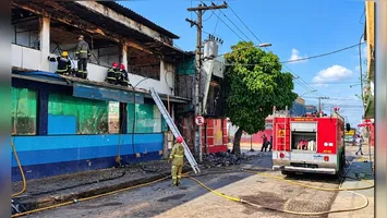 Bombeiros trabalham na operação de rescaldo após o incêndio destruir as estruturas da farmácia UltraPopular e da loja Fill a Fill na Cidade Nova.